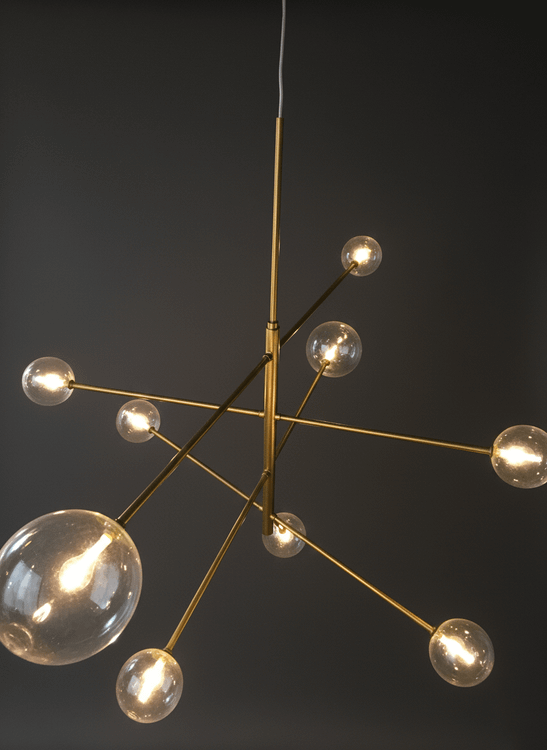 لوستر بالای میز ناهارخوری چوبی بلند در فضایی با سقف اکسپوز و نورپردازی مدرن صنعتی.