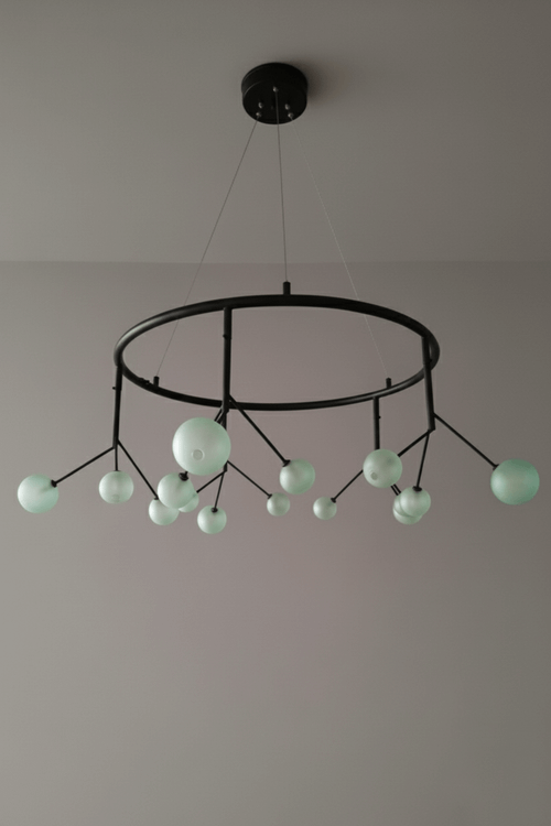 لوستر مدرن مینیمال با بدنه فلزی مشکی مات و حبابهای کروی شیشهای سبز مات در اندازههای مختلف.